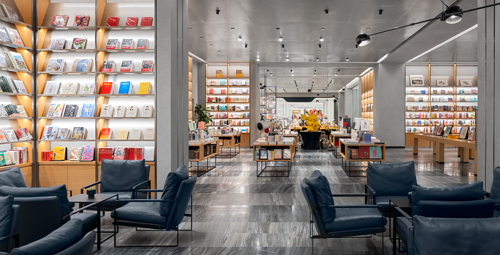 SKP Chengdu bookshop interior with illuminated shelving, lounge seating, display tables.