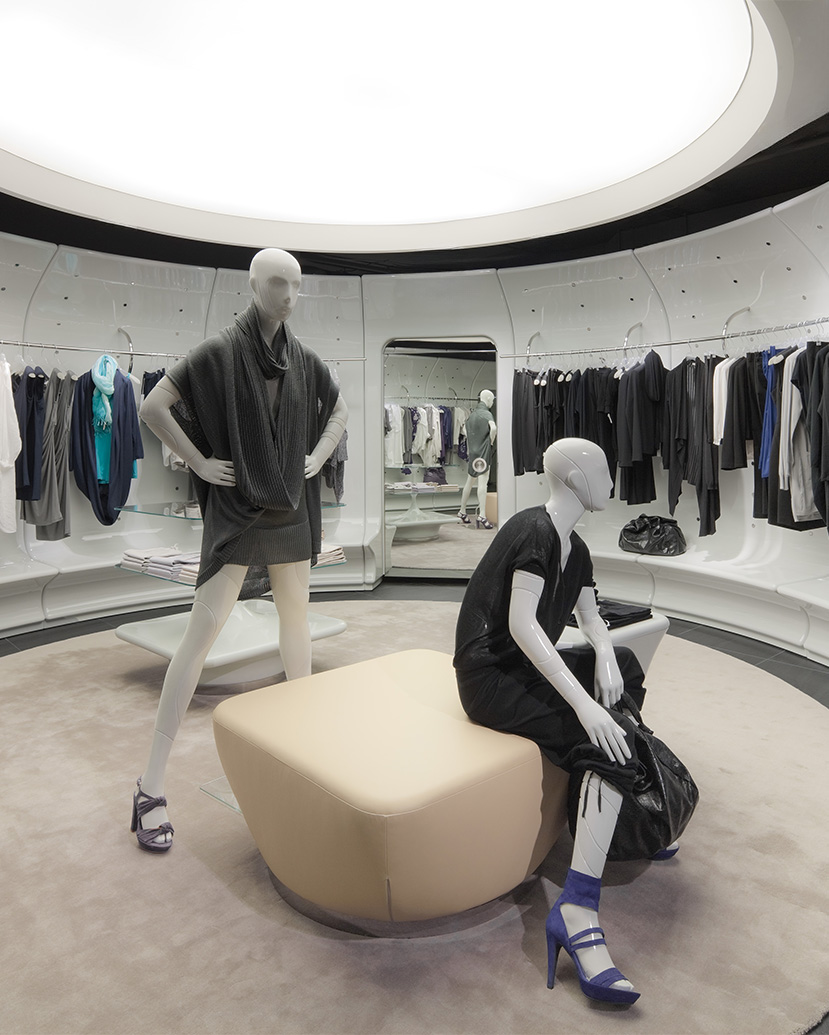 The Stefanel interior uses a circular retail plan, sculptural white display rails and soft overhead lighting to create a fluid, gallery-like environment for fashion presentation.