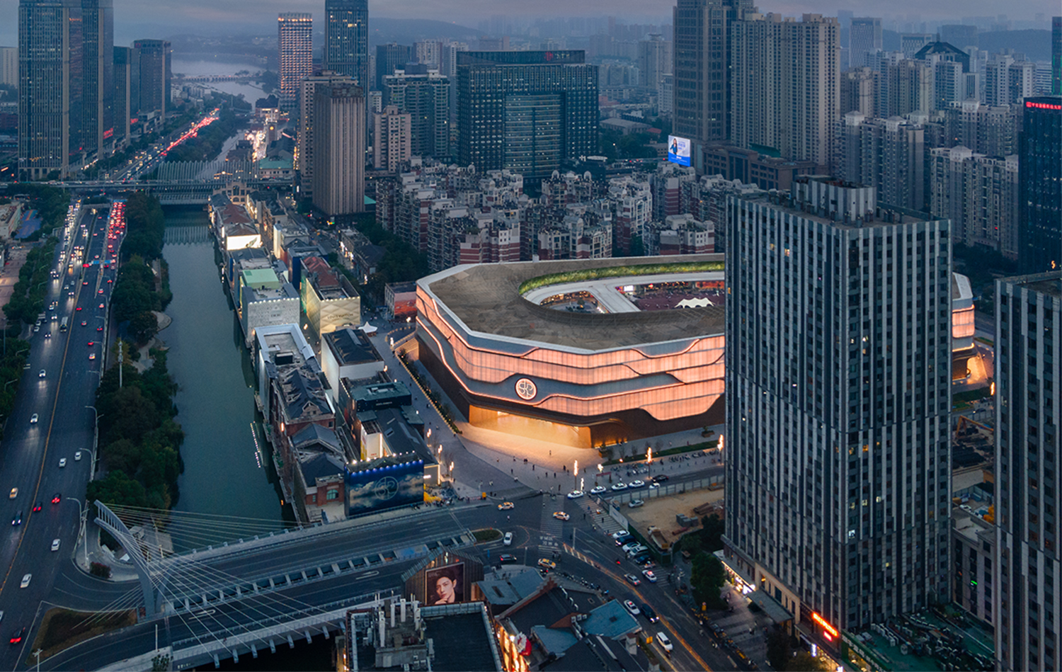 SKP Wuhan is set within the density of the city, its softly illuminated façade and flowing SKP Curve creating a distinctive urban landmark that connects luxury retail with the surrounding streets, canal and skyline.