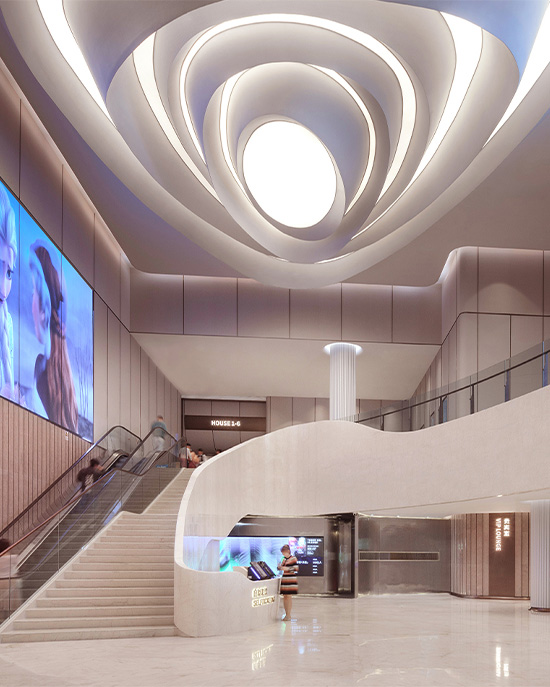 The MixC cinema interior creates a cinematic sense of arrival, with sculptural ceiling forms, sweeping staircases and integrated digital screens shaping an immersive hospitality experience.